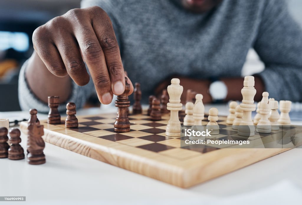 You only win by knowing your opponent's next move Shot of an unrecognizable businessman playing chess in his office Chess Stock Photo