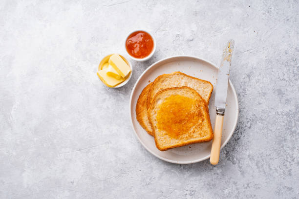 morning toasts with butter and confiture. top view, copy space. - butter bread breakfast table photos et images de collection