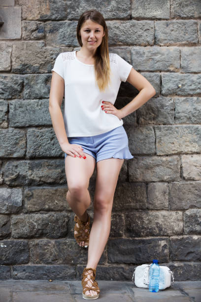 istock Young woman resting against old stone wall 1166906002
