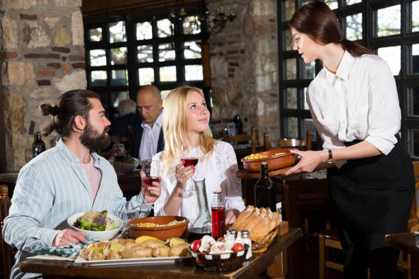 istock Happy people having dinner at rural restaurant and drinking wine 1166906969