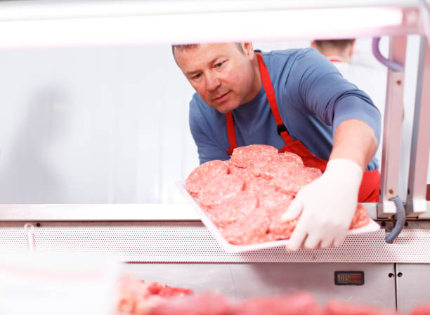 istock Smiling man putting food into display in shop 1166907234