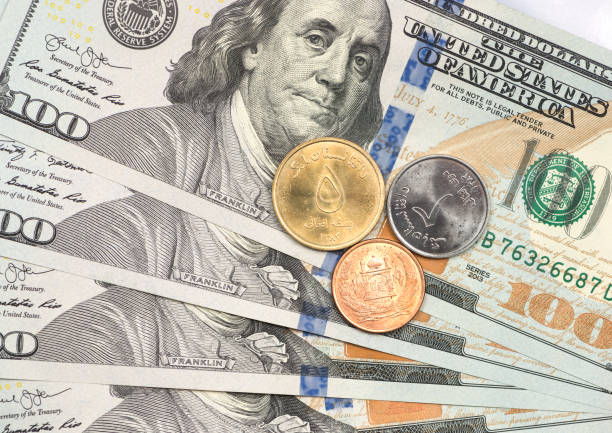 istock Afghani coin on top of dollar bills 1166908009