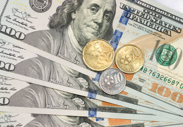istock Malaysian Ringgit coin on top of dollar bills 1166908014