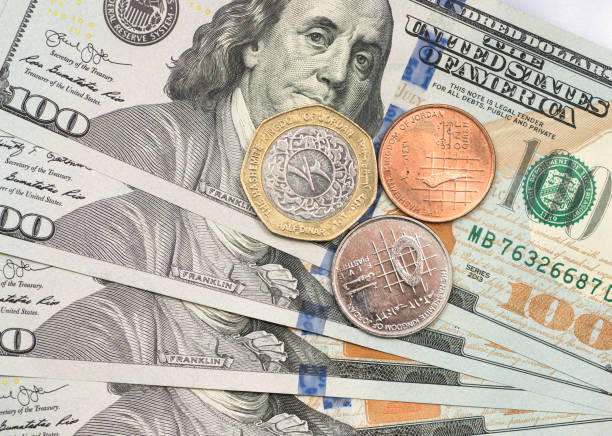istock Jordanian Dinar coin on top of dollar bills 1166908043