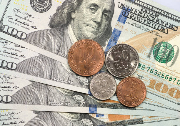 istock Qatari Rial coin on top of dollar bills 1166908047
