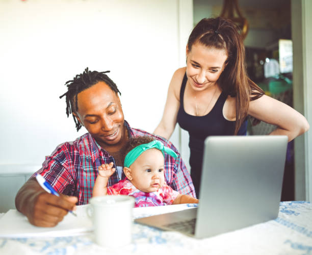 istock African American dad works on a computer with his infant daughter with mom family using computer 1166922514