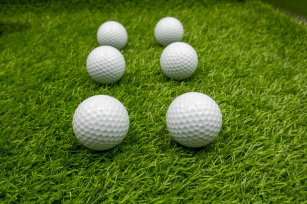 Six golf balls are on green grass