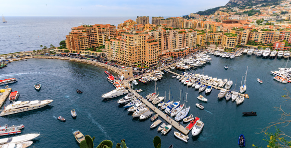 Panorama of the marina in Monaco Ville with luxury yachts and apartments in harbor of Principality of Monaco, Cote d'Azur or the French Riviera