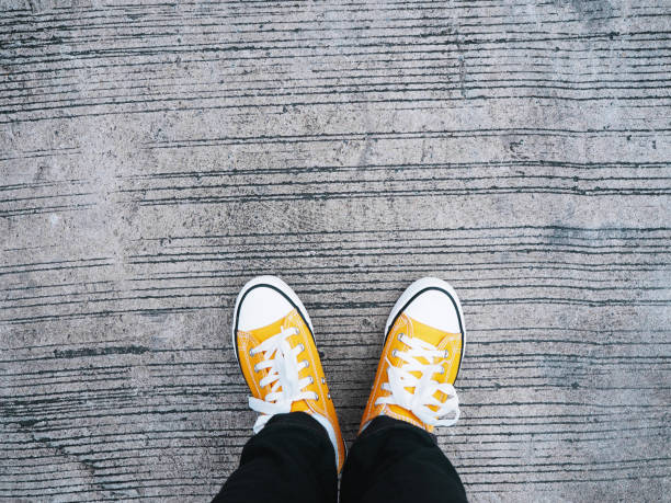 istock feet wearing yellow sneakers 1166930917