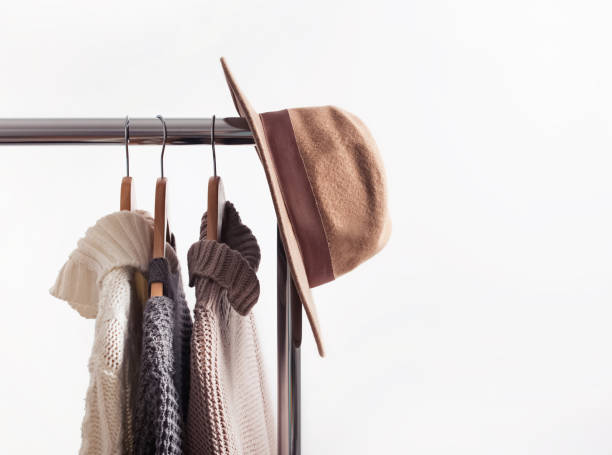istock Knitted sweaters on hangers and felt hat 1166940589