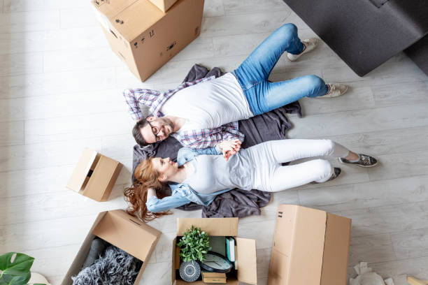 istock Young couple lying at the floor in empty room with unpacked boxes all arround 1166941574