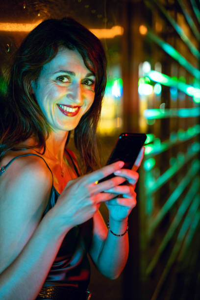 istock Pretty woman using smart phone at the street 1166944178