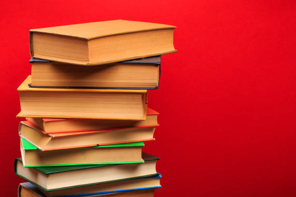 istock pile of old books, panorma, good copy space  on red background - Image 1166947487