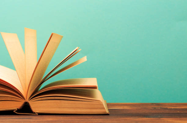 istock Open book on wooden vintage table blue background - Image 1166947497