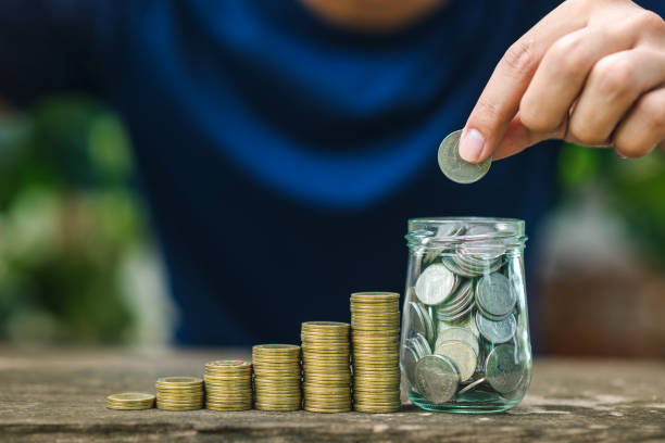 istock Save money concept with hand holding coin on coins stack growing business 1166950173