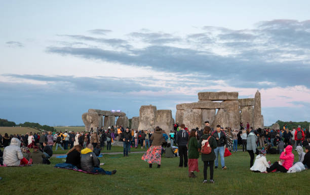 people are gathering at the stone henge stock photo