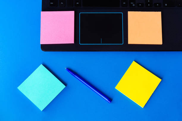 istock stickers for notes near the laptop on a blue background. 1166951762