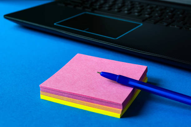 istock stickers for notes near the laptop on a blue background. 1166951811