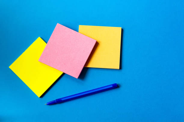 istock stickers for notes and pen lie on a blue background. 1166951817