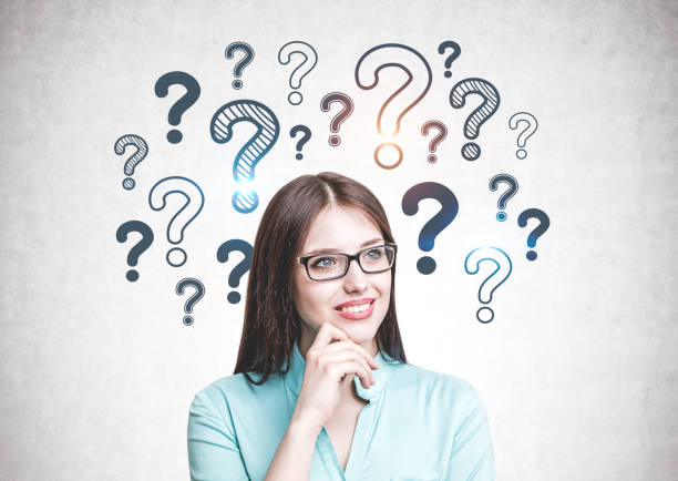istock Smiling woman in glasses, question marks 1166959453