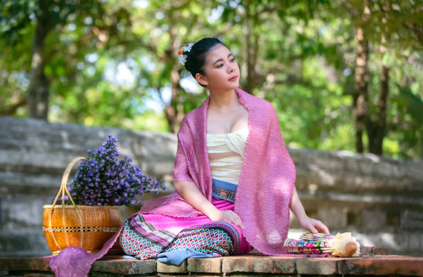 istock Woman Looking Away While Sitting Against Trees 1166969930