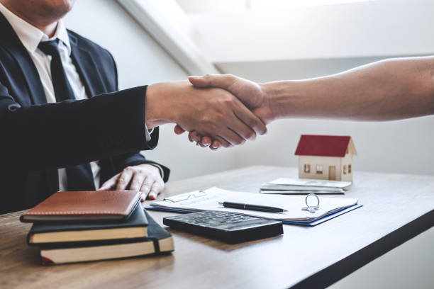 istock Midsection Of Insurance Agent And Client Shaking Hands On Table 1166972536