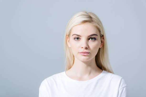 istock beautiful blonde girl looking at camera isolated on grey with copy space 1166976747