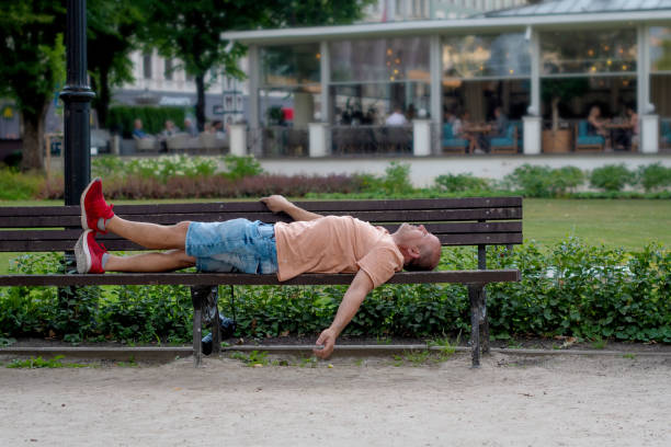 istock A middle age man lying on a bench in the park. 1166976822