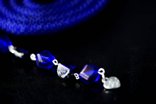istock Long open necklace (lariat) blue color on a dark background close up 1166980993