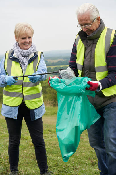 istock Helpful Senior Couple Collecting Litter In Countryside 1166982021