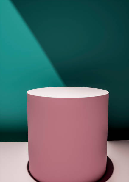 istock Pink circular display plinth against a green wall 1166982200