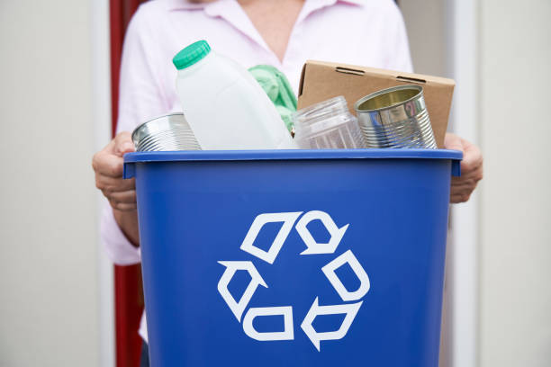 Close Up Of Woman Holding Recycling Bin Of Reusable Waste Outside Front Door Close Up Of Woman Holding Recycling Bin Of Reusable Waste Outside Front Door recycling bin photos stock pictures, royalty-free photos & images