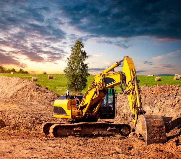 istock Excavator at a construction site. In the background a field with straw bales. 1166984576