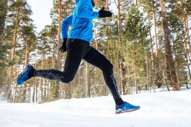 legs athlete runner run through the winter forest training"n