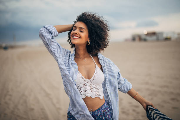 istock Stunning young woman standing on the beach 1166985809