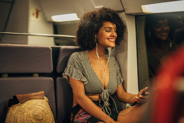 istock Curly haired woman riding in subway train 1166986680