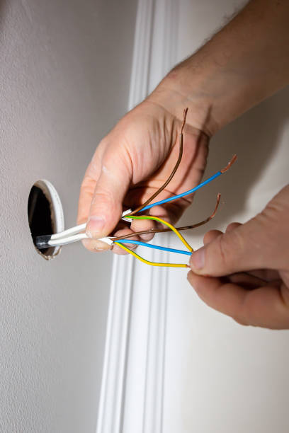 istock Man is holding adhesive tape in his hands.  Electrical insulator for light bulb. Maintenance repair works in the flat. Restoration indoors. 1166988408