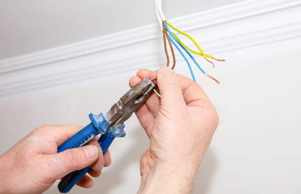 istock Man is holding pliers in his hands. Electrical insulator for light bulb. Adhesive tape for maintenance repair works in the flat. Restoration indoors. 1166988691
