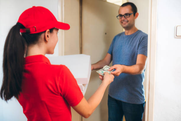 istock Young Woman Delivering Pizza To man 1166990817