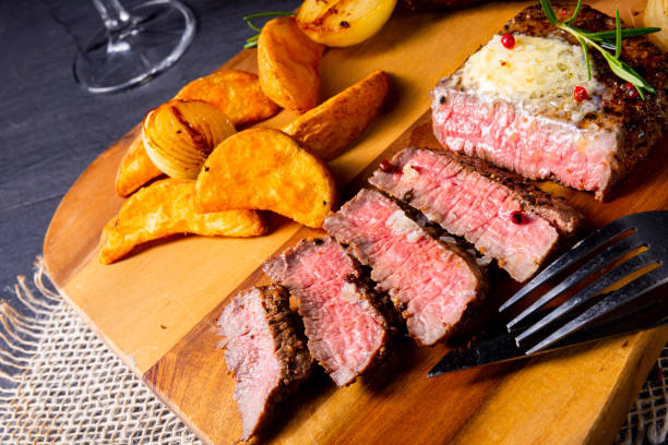 rustic medium butter beef steak with herbs and potato wedges - close to food and drink yummy food imagens e fotografias de stock