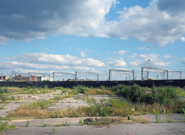 un grande sito di brownfield urbano inutilizzato con terreno aperto coperto di cemento incrinato invaso in attesa di sviluppo in leeds inghilterra - terra brulla foto e immagini stock