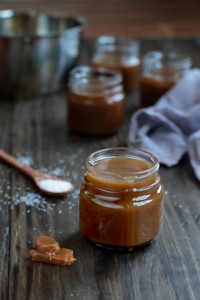 istock Little jars of salted caramel sauce over a rustic table 1166994239