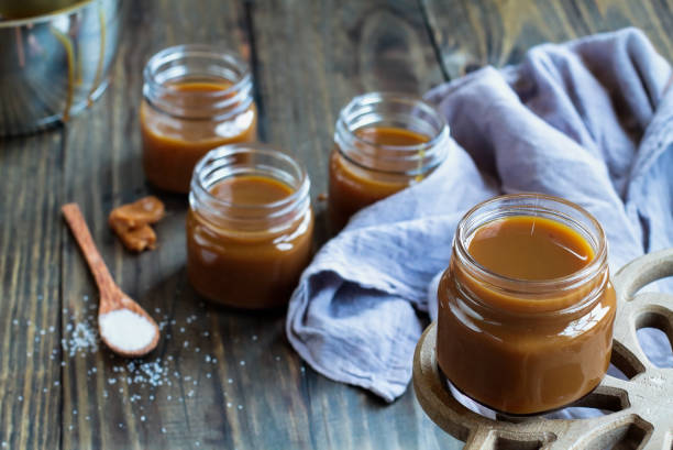 istock Little jars of salted caramel sauce over a rustic table 1166994346