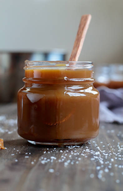 istock Little jar of salted caramel sauce over a rustic table 1166994517