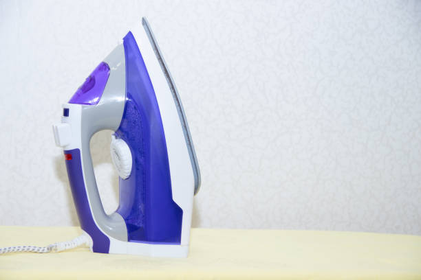 istock Two irons on an ironing board. Selection and comparison of irons. Ironing board. 1166994677
