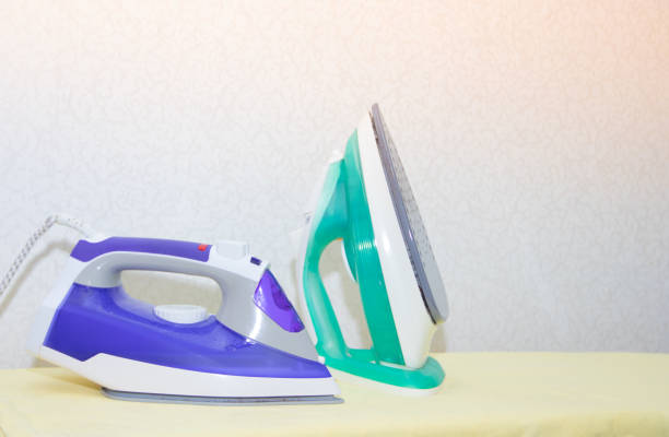 istock Two irons on an ironing board. Selection and comparison of irons. Ironing board. 1166994707