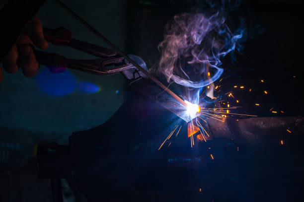 istock Worker with protective gloves welding metal part in workshop. 1166995628