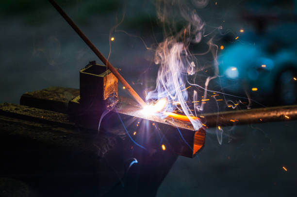istock Worker with protective gloves welding metal part in workshop. 1166995706
