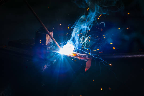 istock Worker with protective gloves welding metal part in workshop. 1166995726
