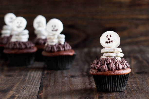 istock Creative concept of skeleton made from white chocolate pretzels and marshmallows over a dark chocolate cupcake 1166997159